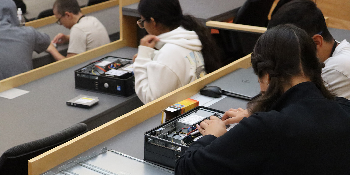 Students shown working with the innards of a computer