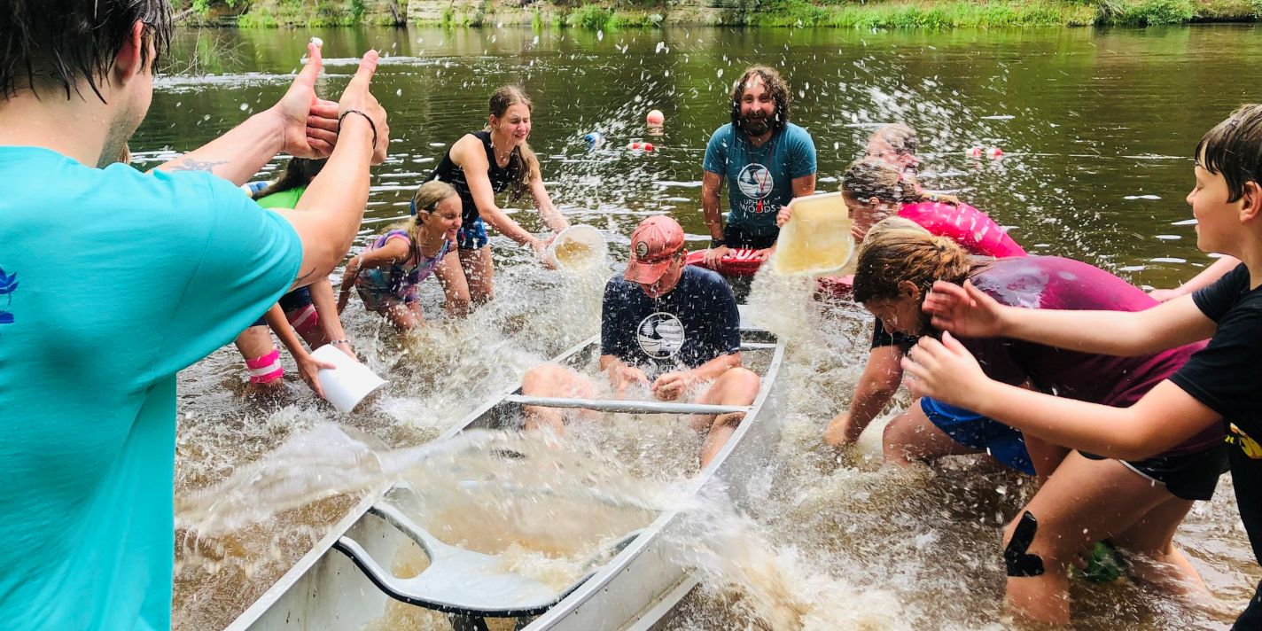 Children fill a canoe with water